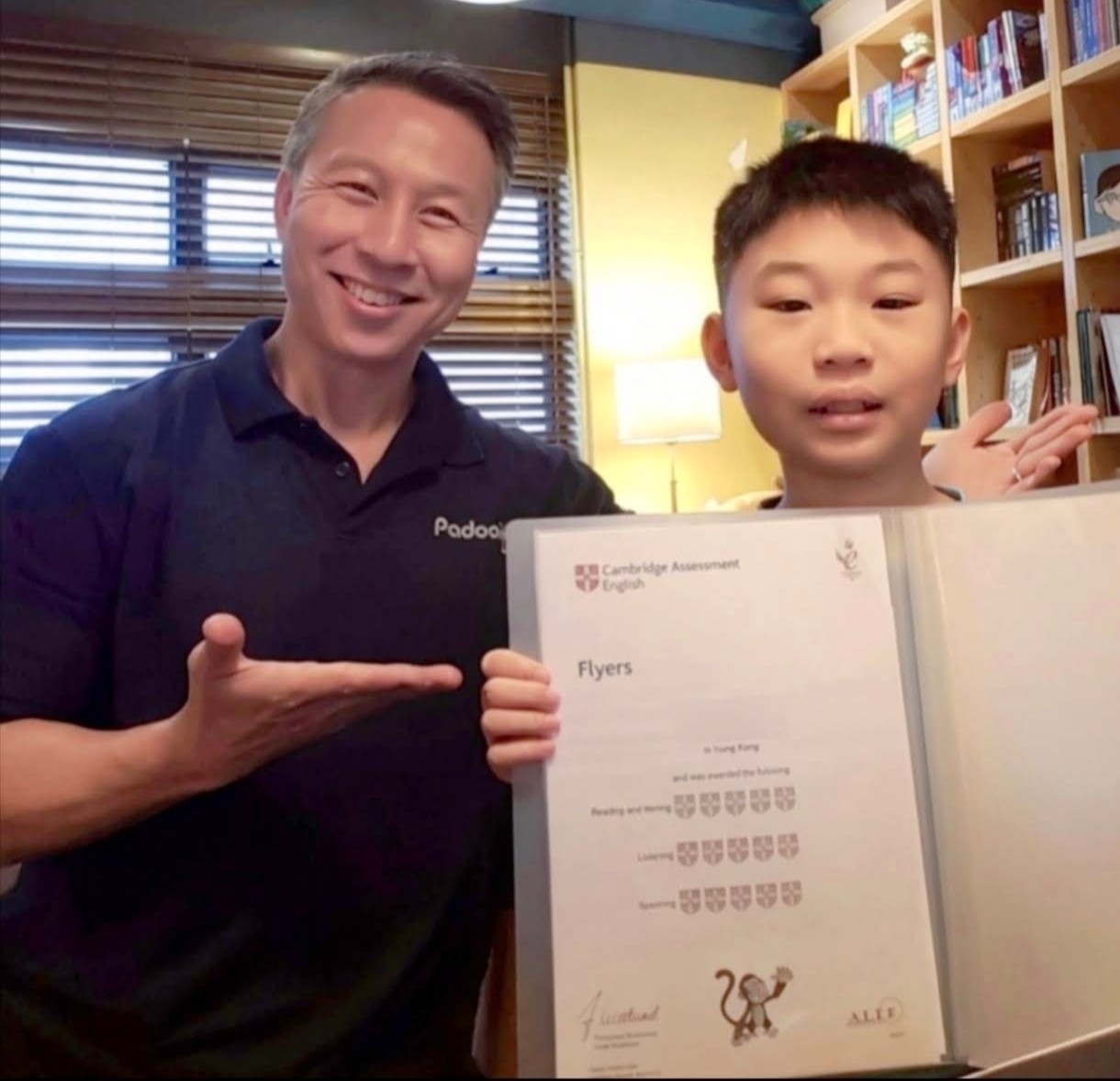 Tutor and student with a Cambridge Assessment English Flyers certificate