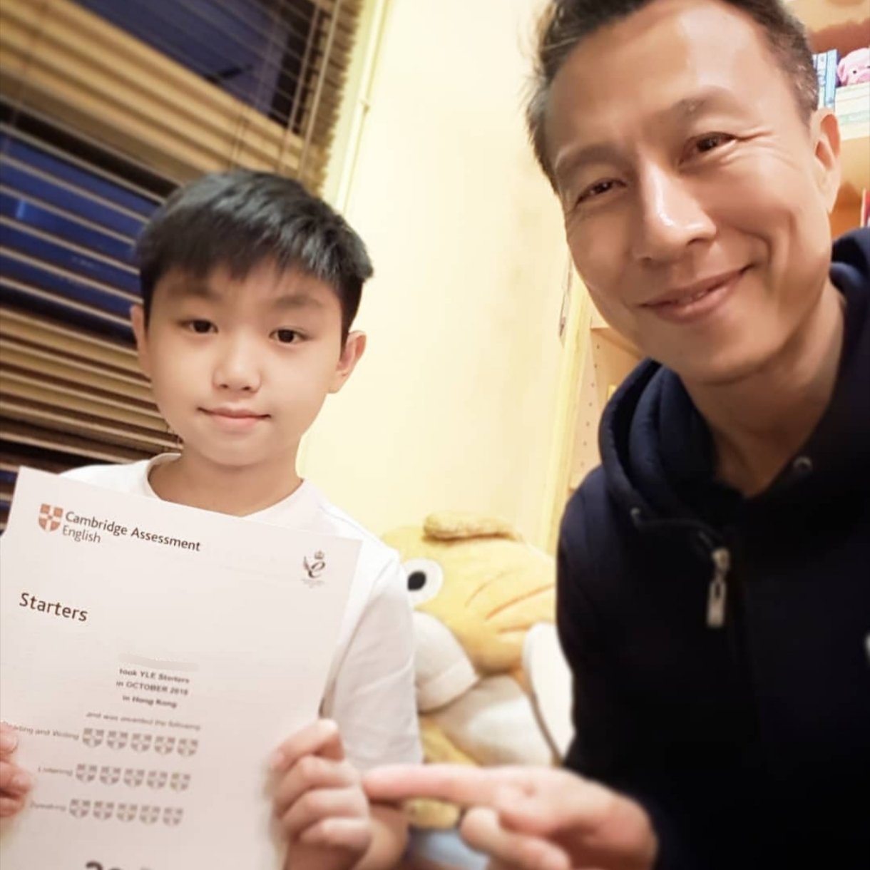 Tutor and student with a Cambridge Assessment English Starters certificate