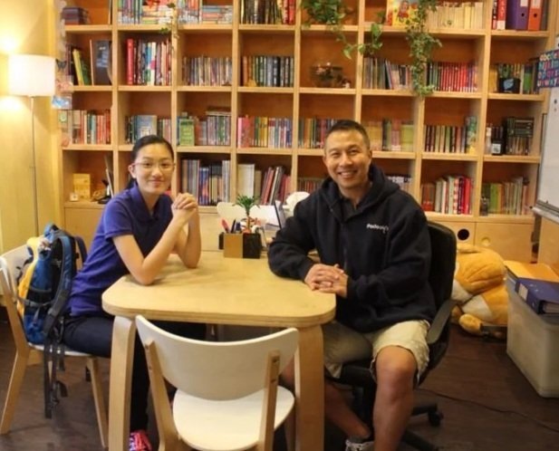 Teacher Mike with a student at the study table